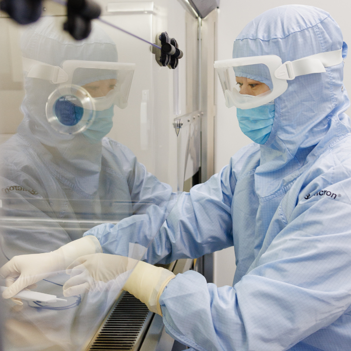 Medewerker van de ziekenhuisapotheek werkt in een steriele omgeving en heeft beschermende kleding aan