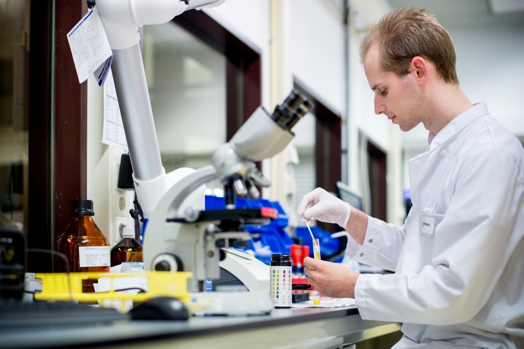 Onderzoeker in lab met microscoop Onderzoeker in lab met microscoop
