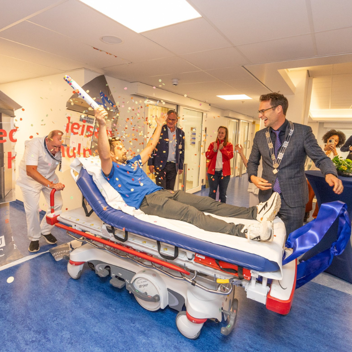 Foto van de opening met blije gezichten en applaudisserende mensen.