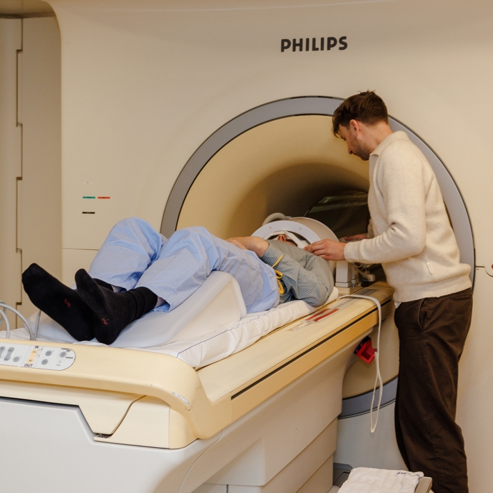 Two researchers positioning a research participant into the MRI scanner