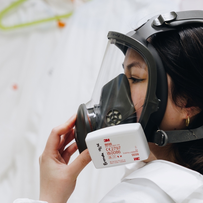 Researcher with protective headgear working with viruses at BSL3 