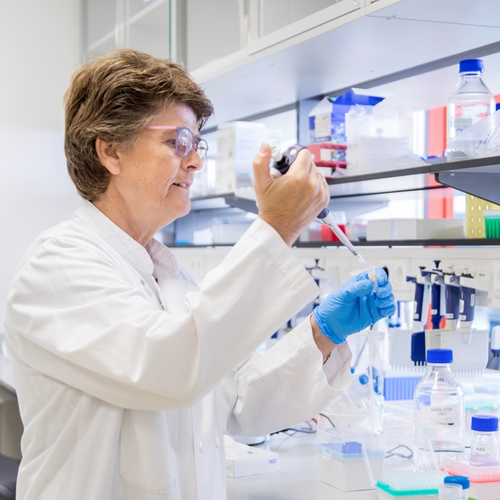 Researcher performs pipetting in lab