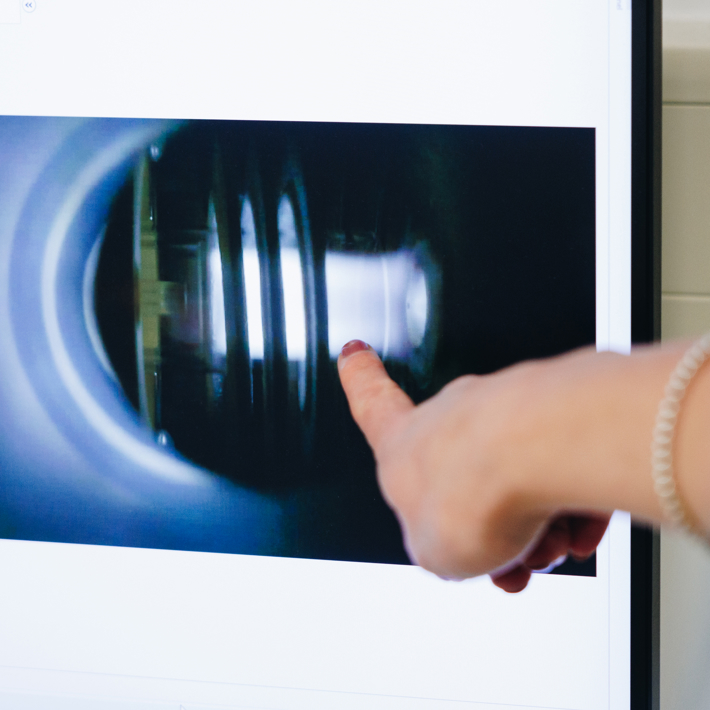A close-up of a hand pointing to something on a screen