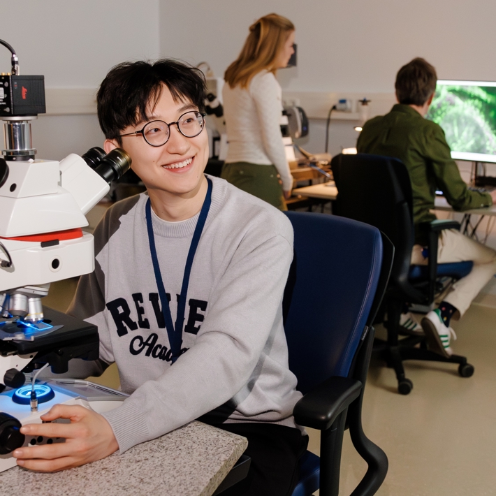 People interacting and operating different microscopes