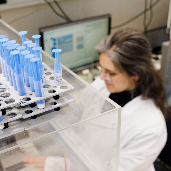 Pipettes on device in lab with researcher working in the background