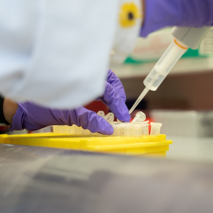Close-up of researcher in lab pipetting